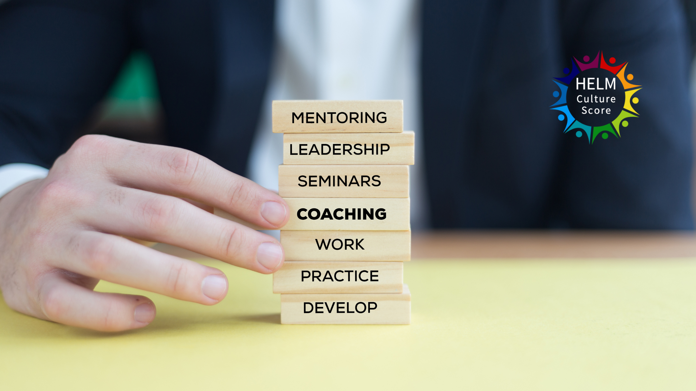 Executive coaching concept with stacked wooden blocks showing mentoring, leadership and coaching, HELM Culture Score logo