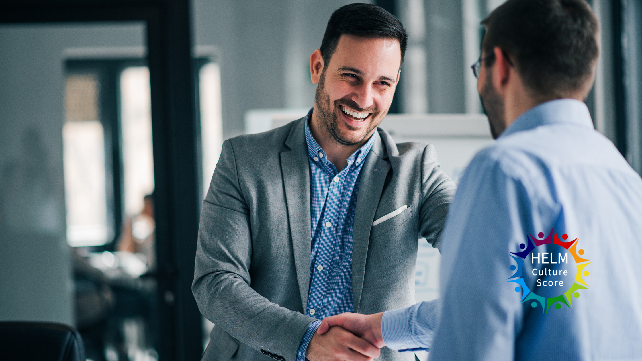 Two business professionals shaking hands in office, symbolising choosing a coach, with HELM Culture Score logo